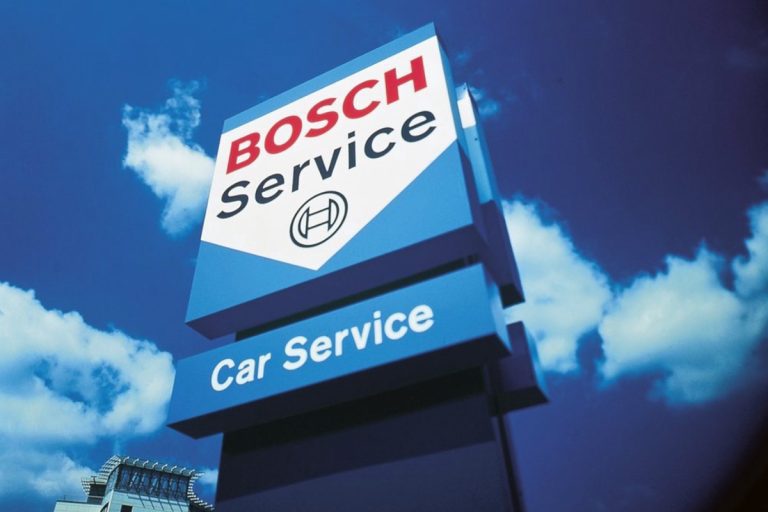 A view of a Bosch car service pillar against a blue sky with clouds
